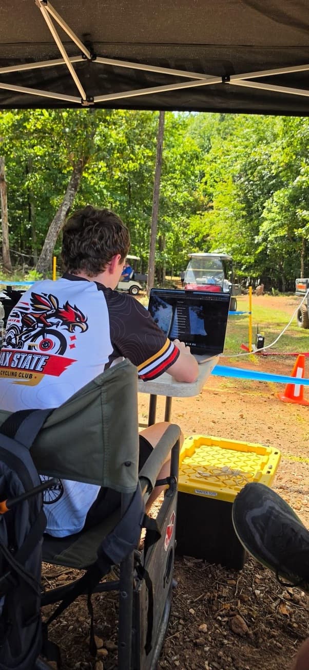 Matthew operating the Time2Bike infrared timing system at TMU’s dual slalom race in 2026